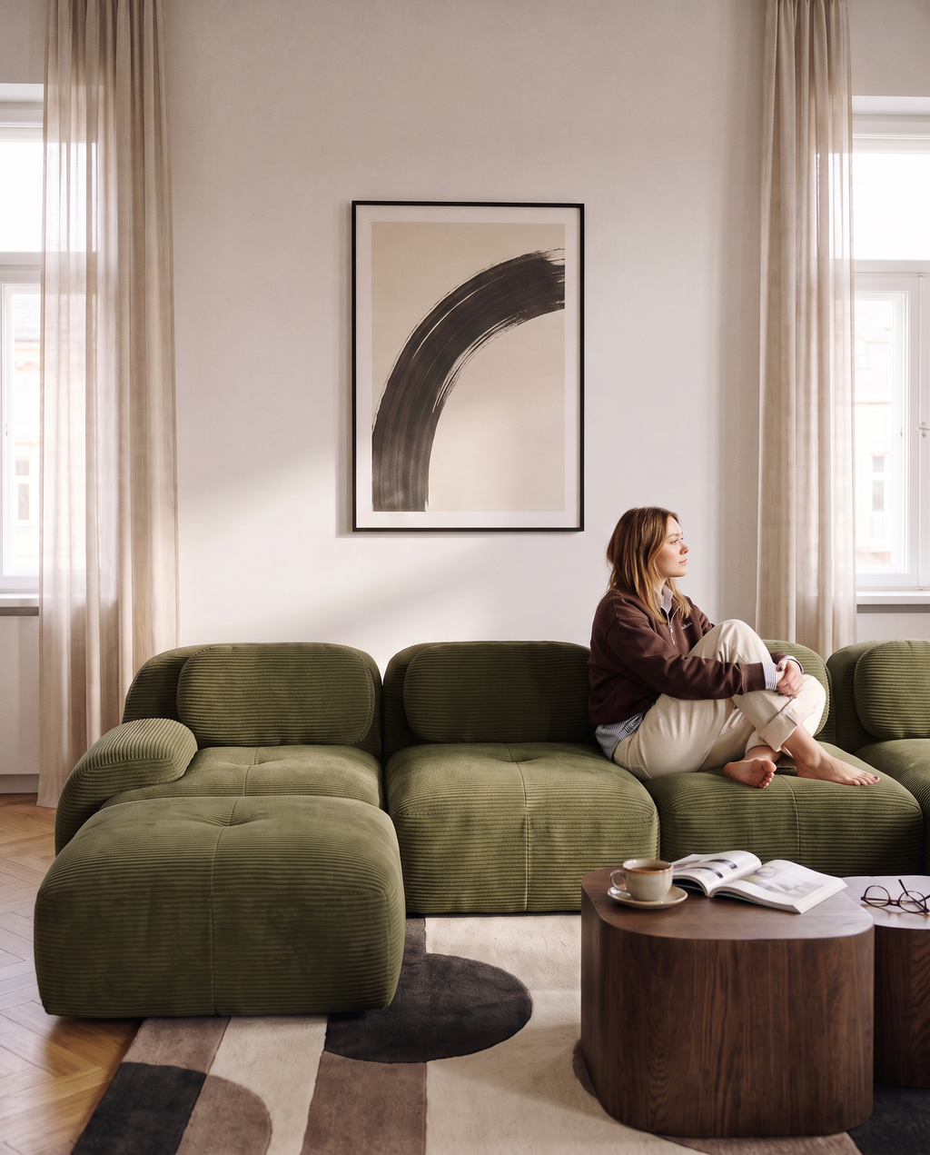 Canapé compressé en U Archipel en velours côtelé vert, femme assise dans un salon lumineux