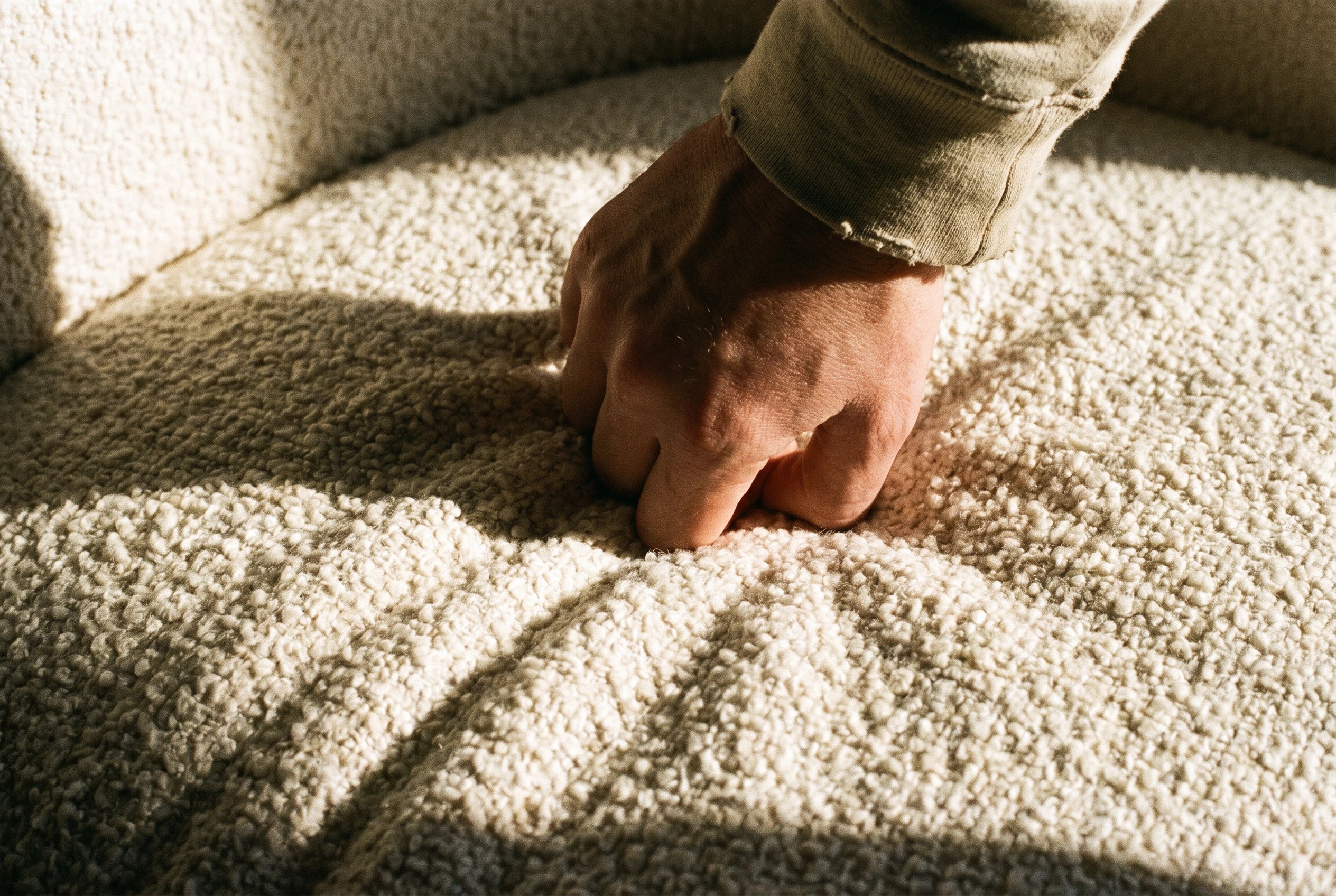 Gros plan sur le tissu bouclette écru du canapé Dune pressé à la main Image